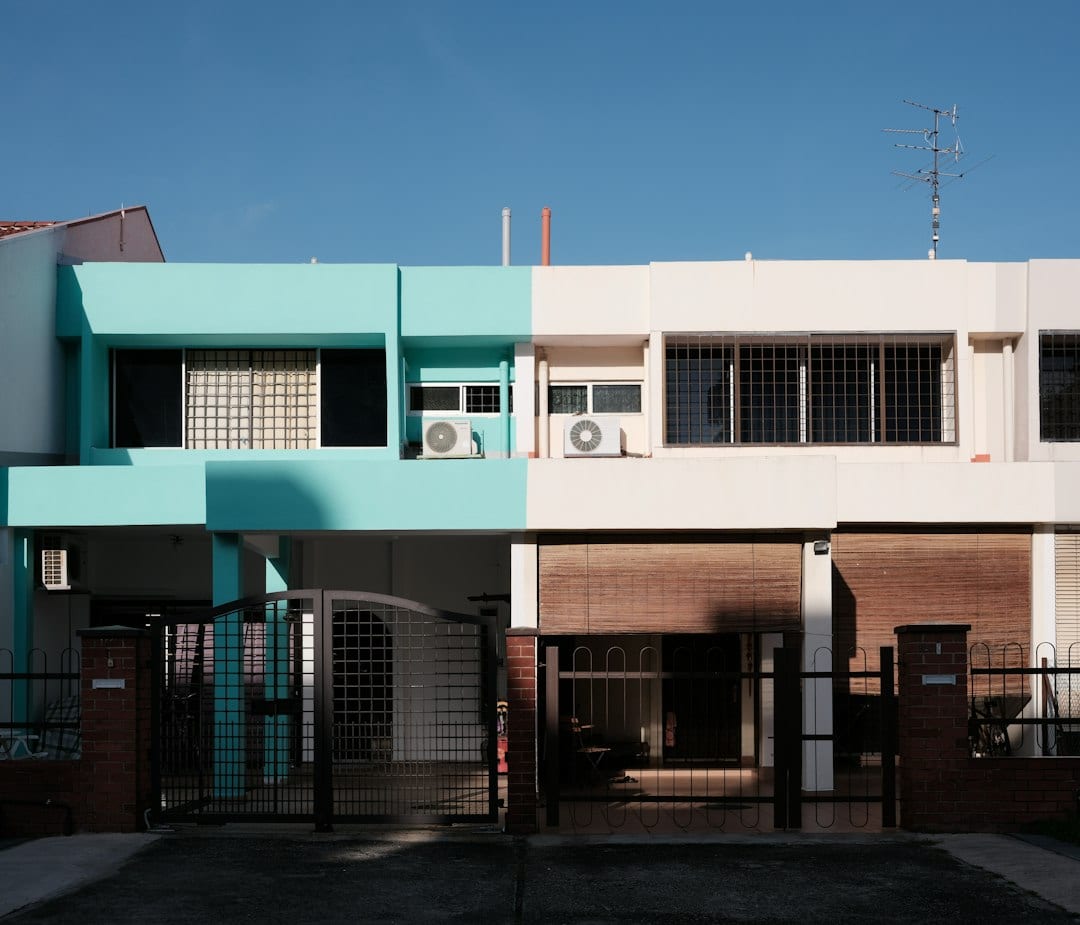 Green and white concrete building under a clear sky